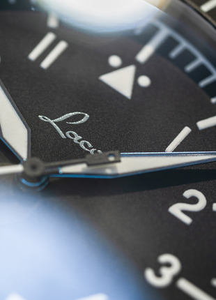 Close-up of Laco Köln Grau matte black pilot watch dial with luminous indexes and blued steel hands