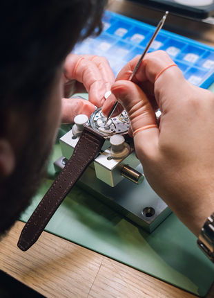 Participant using watchmaking tweezers to handle mechanical watch components during The Watch Academy Level 1 course.