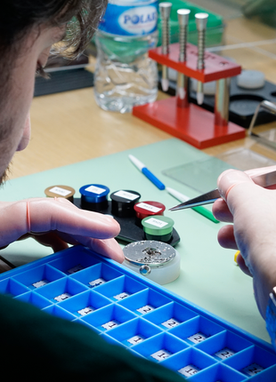 Close-up of a participant using precision tools to work on a mechanical watch movement during The Watch Academy Level 1 workshop.