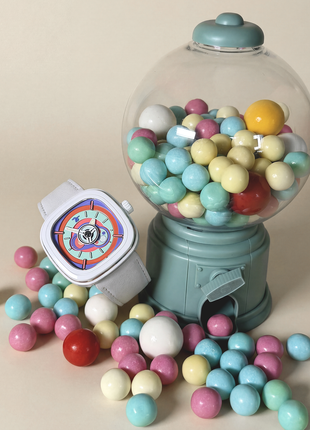 SEVENFRIDAY P1C/06 Bubble Gum displayed beside a gumball machine and pastel sweets